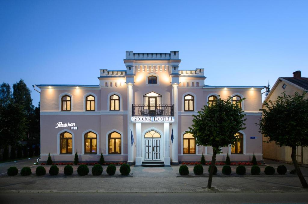 沃鲁格奥尔基酒店的一座白色的大建筑,灯火通明