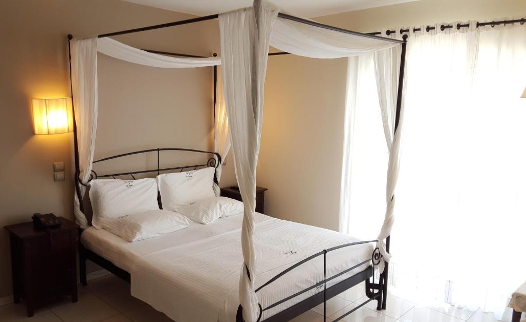 拉夫蒂港Sea Sight Boutique Hotel的一间卧室设有天蓬床和窗户。