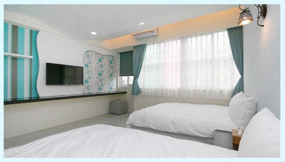 吉安小敏&日森民宿的酒店客房设有两张床和窗户。