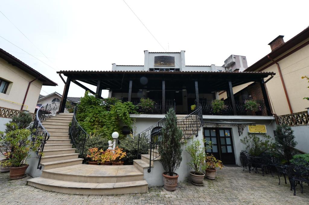 塔古玖Pensiunea Antique的前面有楼梯和盆栽的建筑