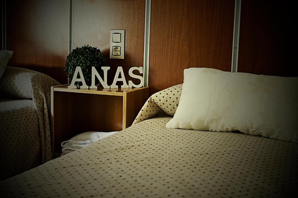梅里达阿纳斯旅馆的卧室配有一张挂有墙上标牌的床