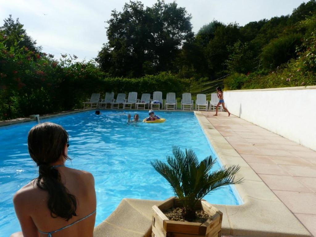 拉巴斯蒂德克莱朗斯Les Chalets de Pierretoun的坐在游泳池里的比基尼女人