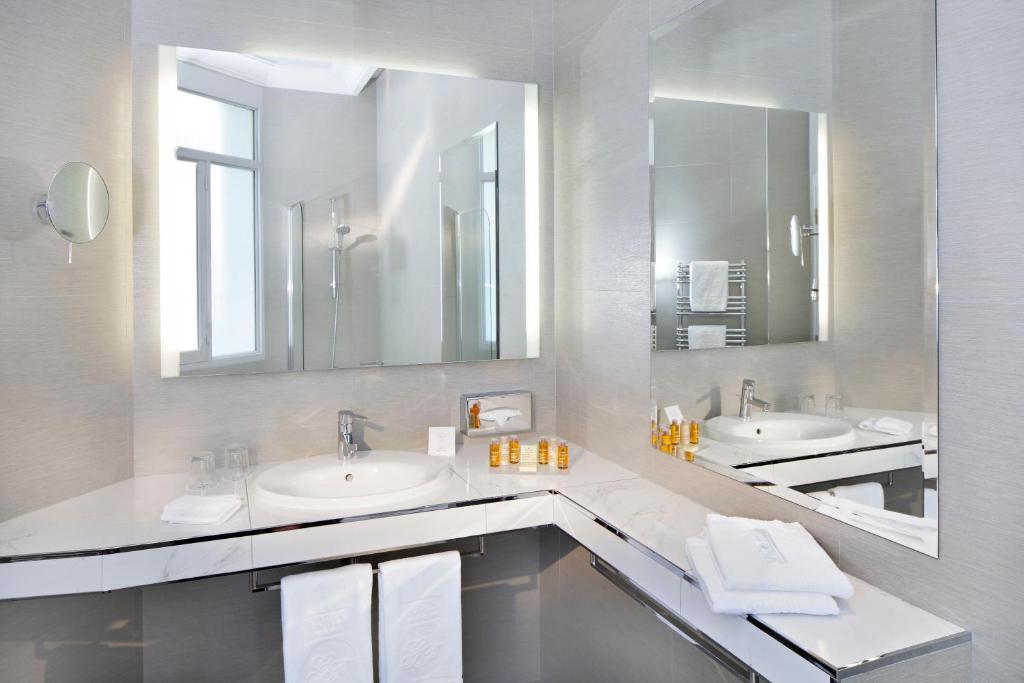 巴黎Hôtel Château Frontenac的浴室设有2个水槽和2面镜子