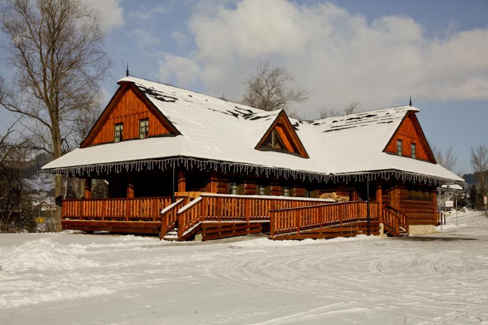 贝谢诺瓦Koliba Bešeňovka的屋顶上积雪的大型小木屋