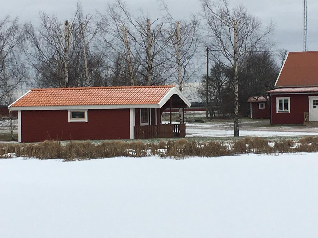 Skänninge格里朋伯格斯加兹布提克乡村民宿的雪中红色屋顶的房子