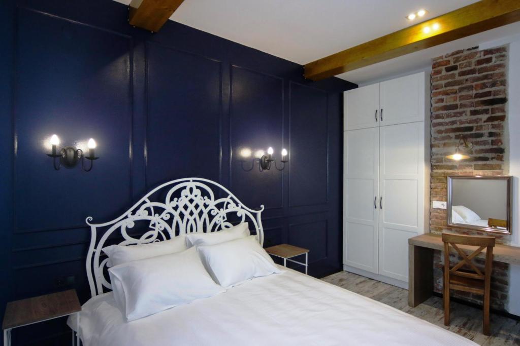 利沃夫Potocki Apartments的卧室配有白色的床和蓝色的墙壁