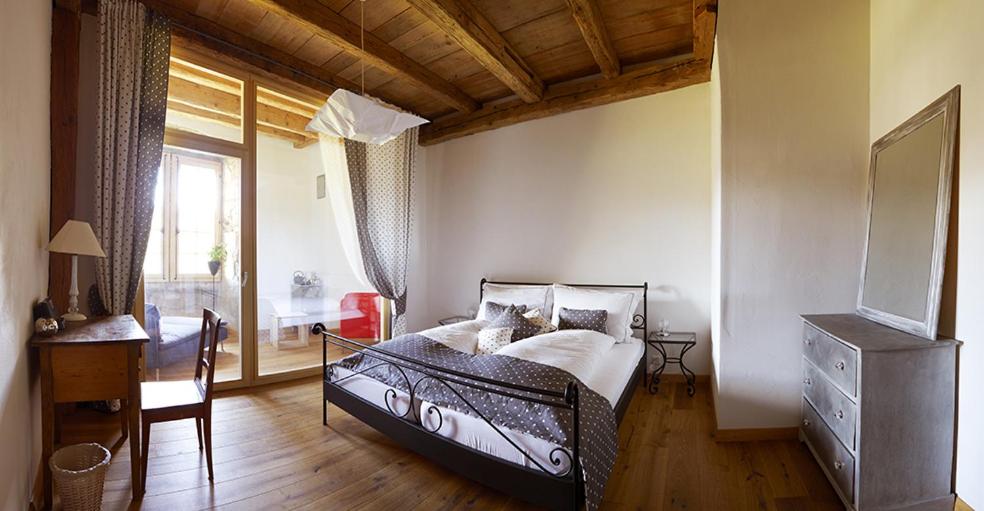 科索奈克芒德里旅馆的一间卧室配有一张床、一张书桌和一个窗户。