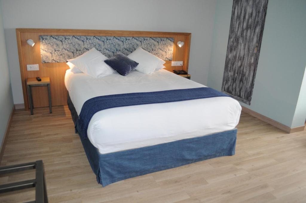 塞拉诺瓦Hotel Celanova的卧室配有一张带白色床单和枕头的大床。