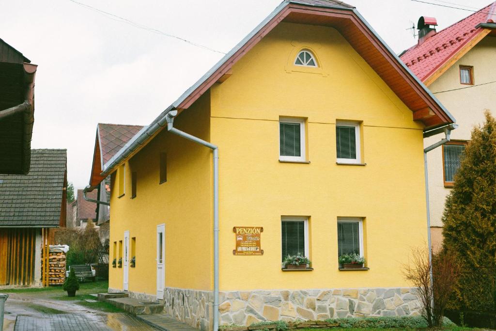斯祖贝莱克Apartmány Bistár的棕色屋顶的黄色房子