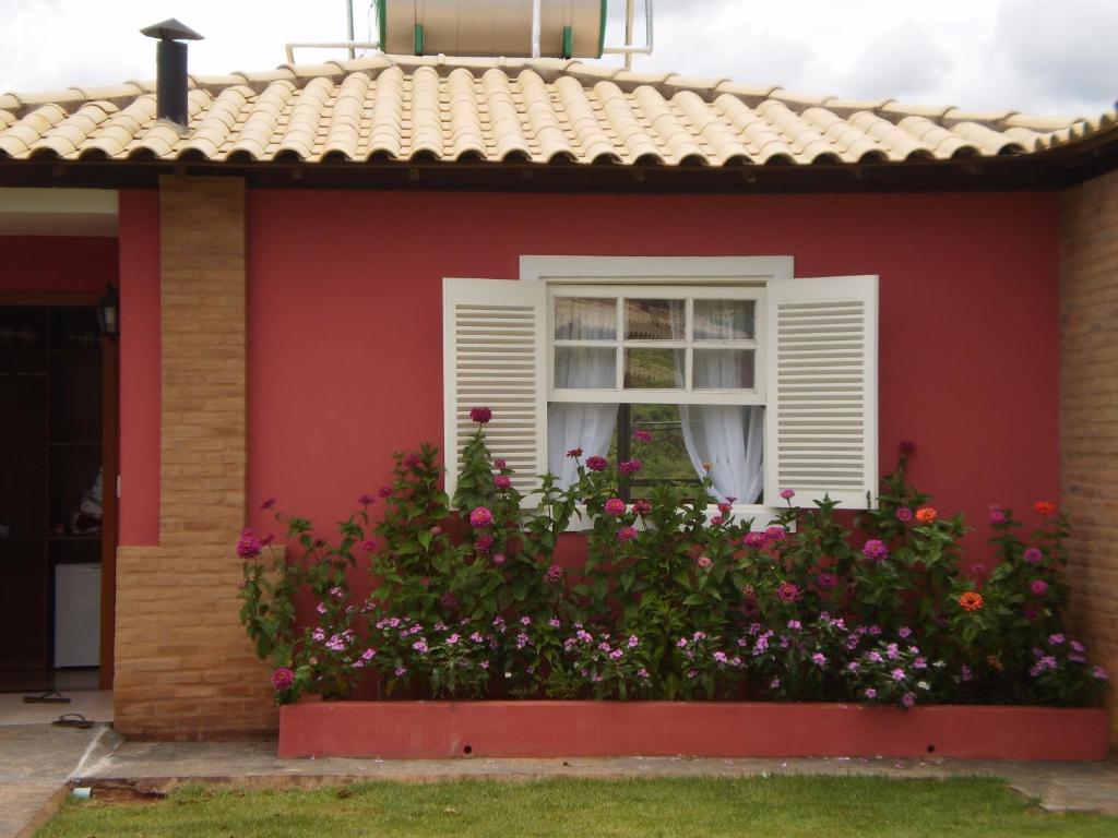 Belo ValePousada Princesa Do Vale的红色的房子,有窗户和鲜花