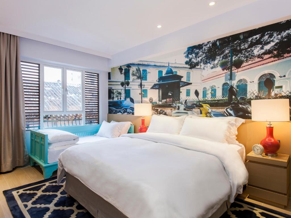 澳门卡尔酒店的卧室内的两张床,墙上有绘画作品