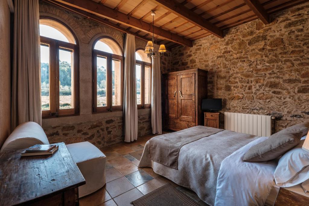 LlaviáCan Barnosell - Els Masos d'en Coll的一间卧室配有床和窗户。