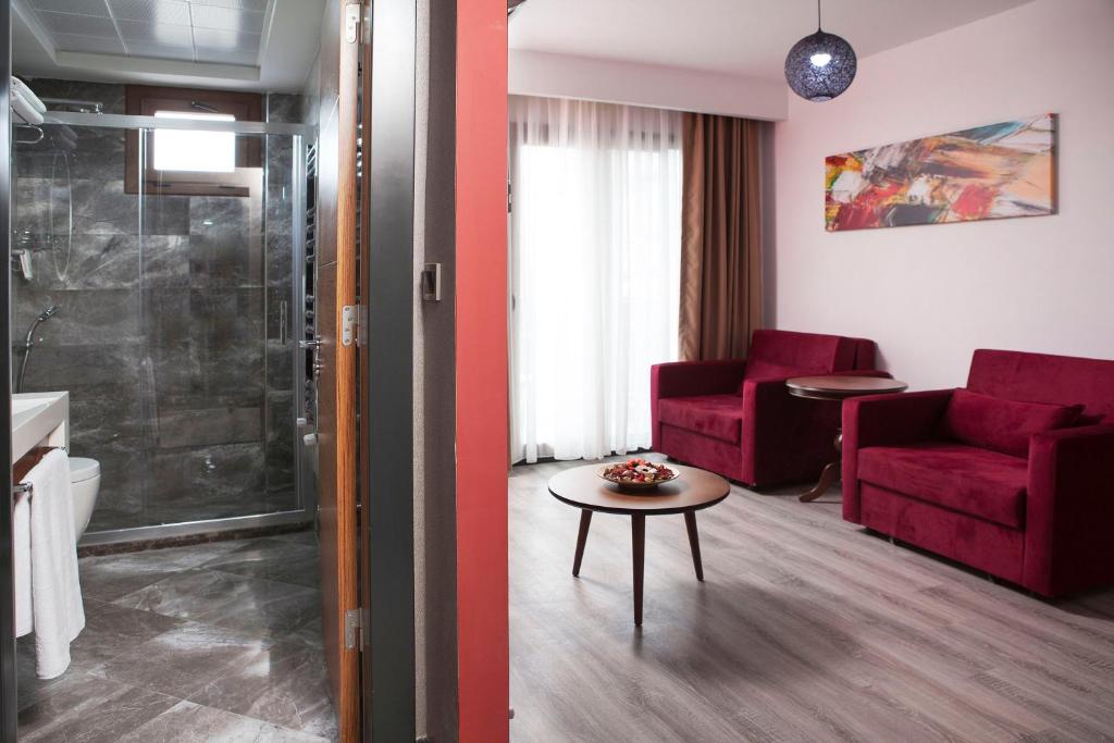 伊兹密尔布卡公寓酒店的客厅配有红色的沙发和桌子