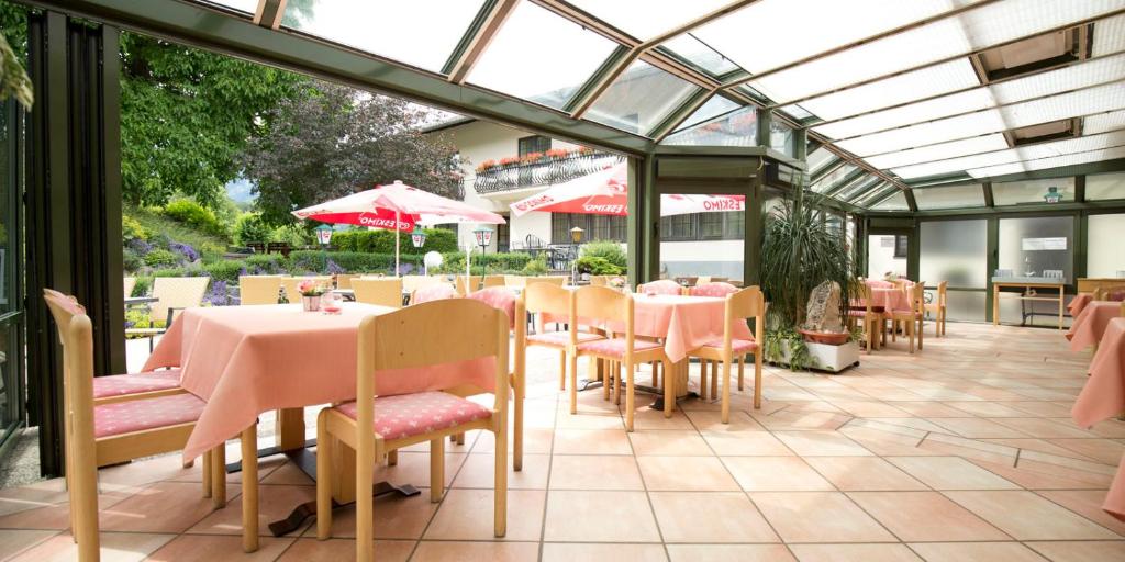 赖兴瑙Flackl - Wirt的温室餐厅,配有粉红色的桌椅