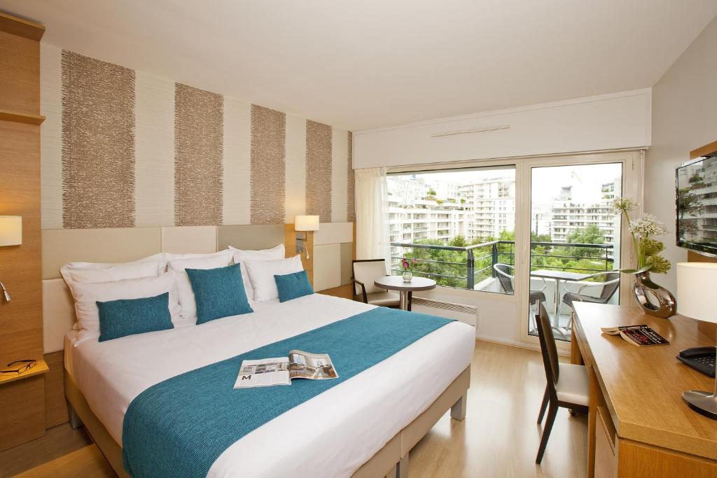 库尔布瓦库尔布瓦拉德芳斯公寓式酒店的酒店客房设有一张大床和一张书桌。