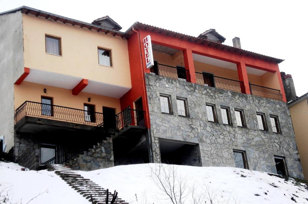 皮索德里Eleni's Guesthouse的一座位于雪覆盖的山顶上的建筑