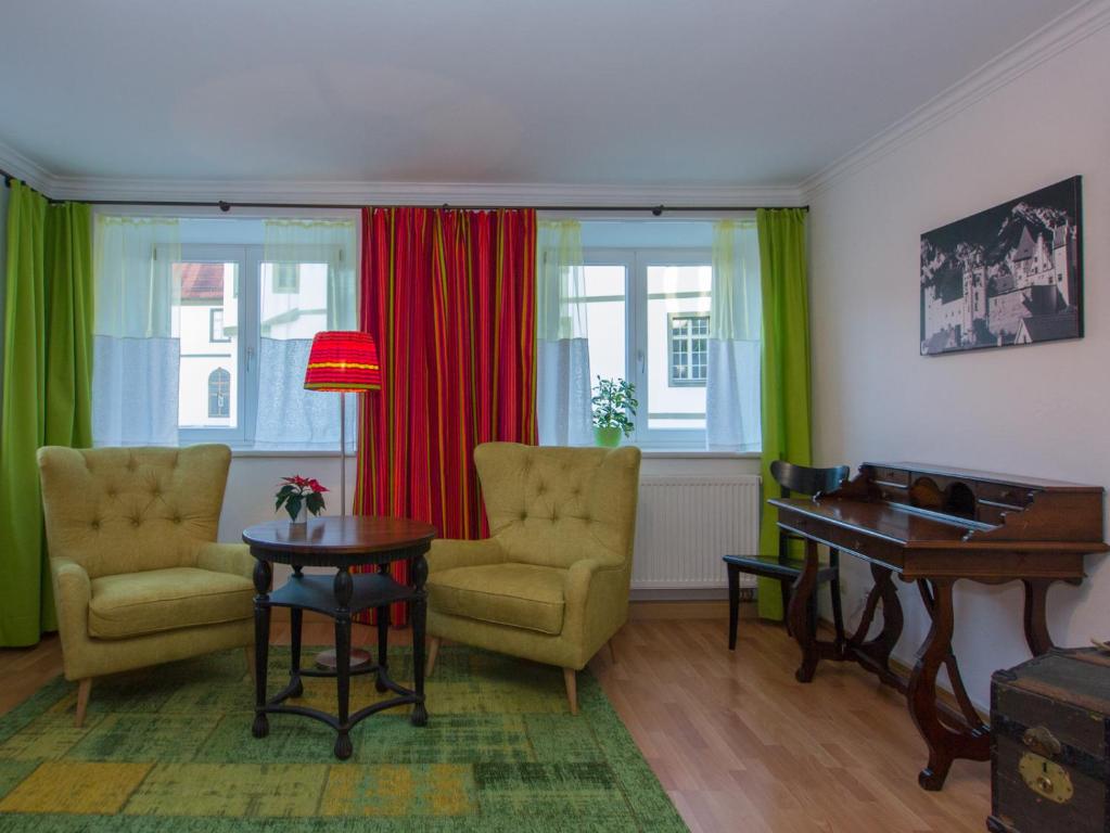 福森Altstadt Ferienwohnung Guade Zeit的客厅配有两把椅子和一张桌子