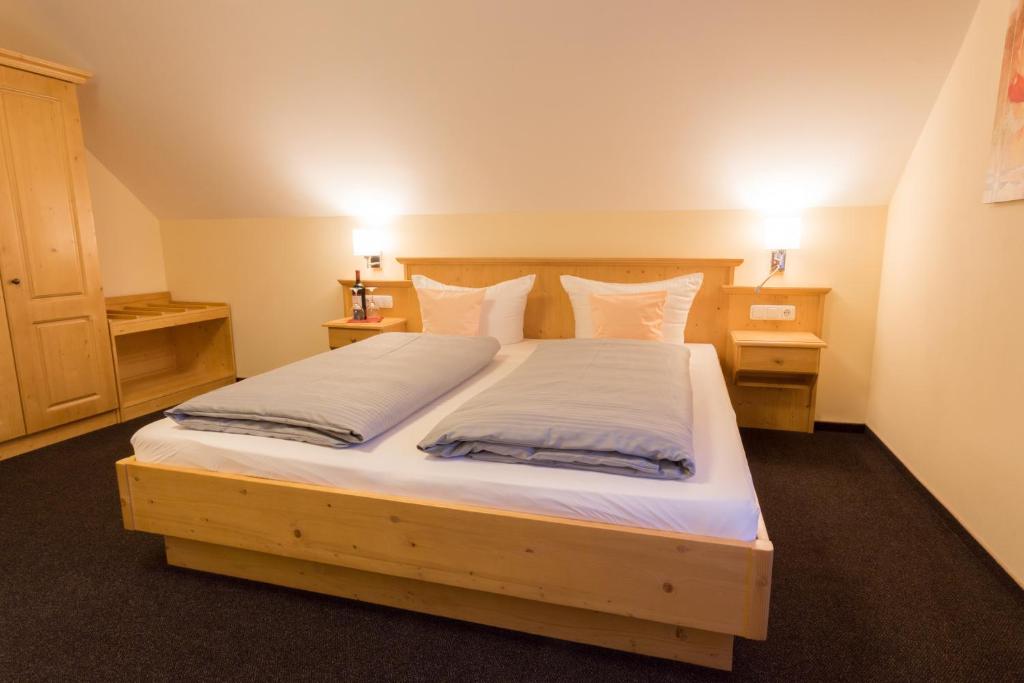 艾恩灵Landhotel Grätz的卧室配有一张带白色床单和枕头的大床。