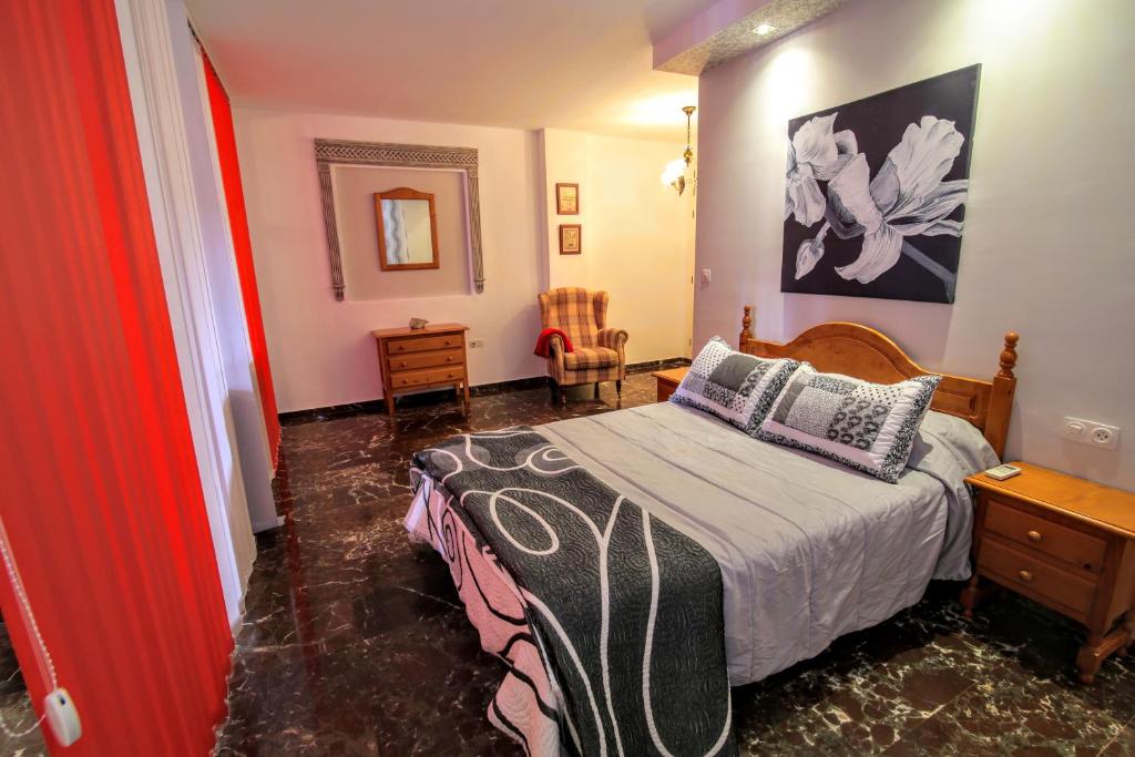 杜尔卡尔Apartamentos Turísticos La Fonda的一间卧室配有一张床、一张桌子和一面镜子