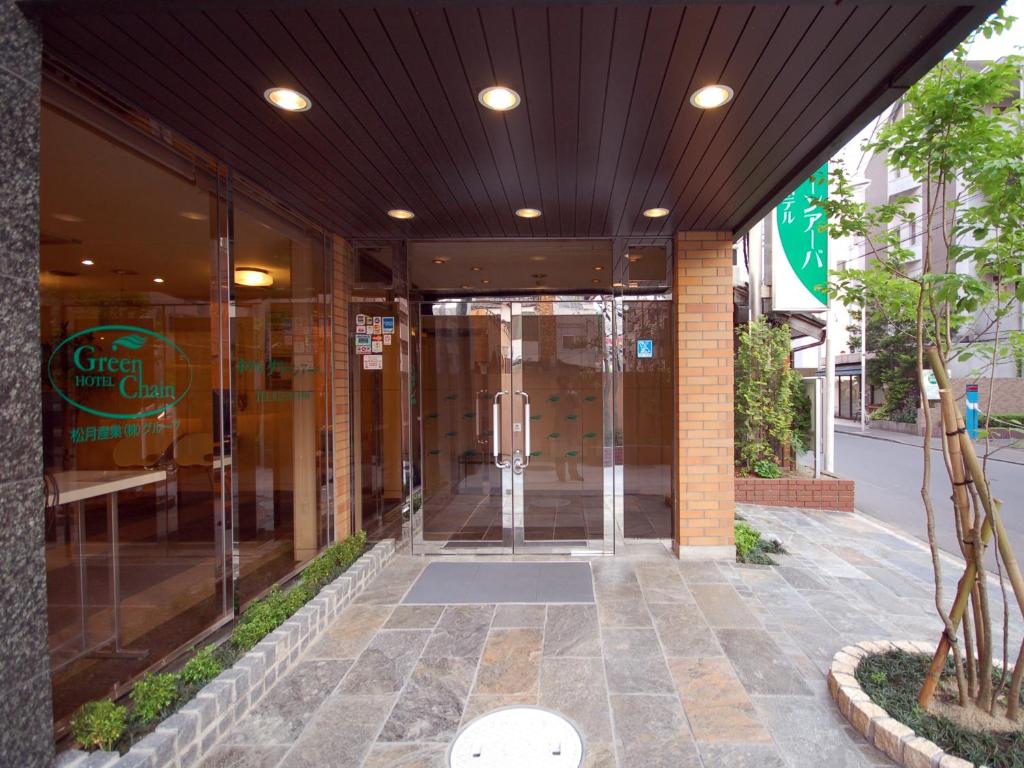 仙台绿色凉棚酒店的玻璃建筑的入口,带旋转门