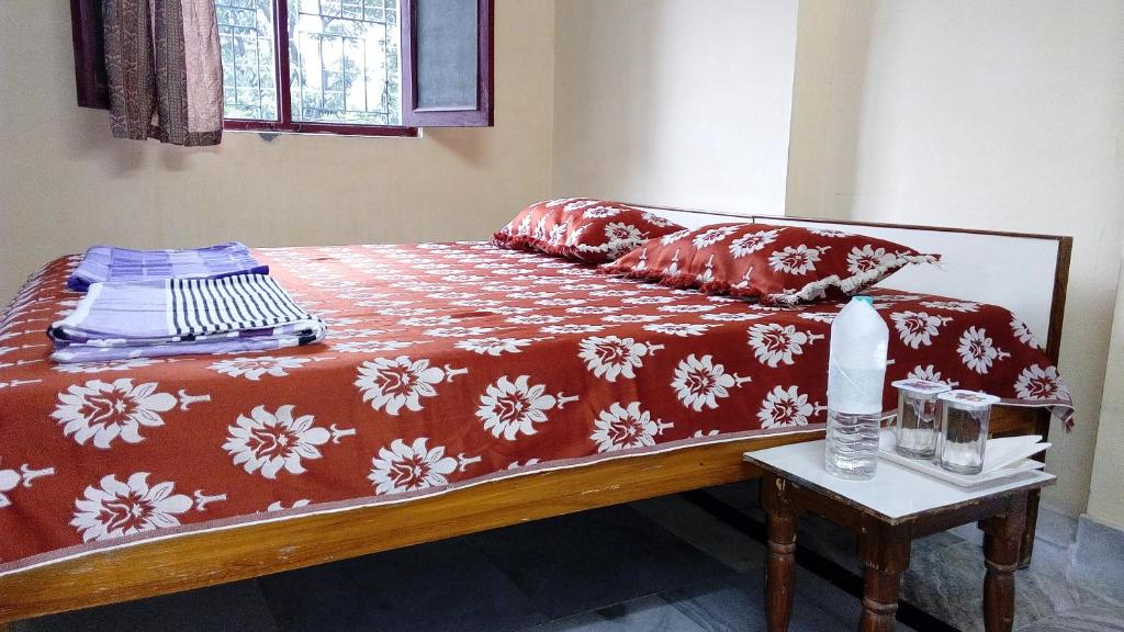 瑞诗凯诗Laxmi Lodge的一张带红白毯子和桌子的床