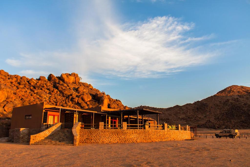 马尔塔赫厄Greenfire Desert Lodge的沙漠中一座有山的建筑