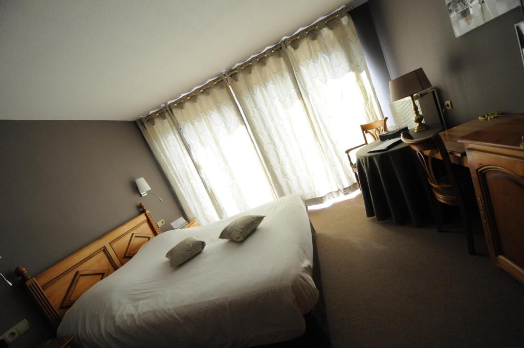 NiederschaeffolsheimLogis Hotel Restaurant Au Boeuf Rouge的一间卧室配有一张带两个枕头的床