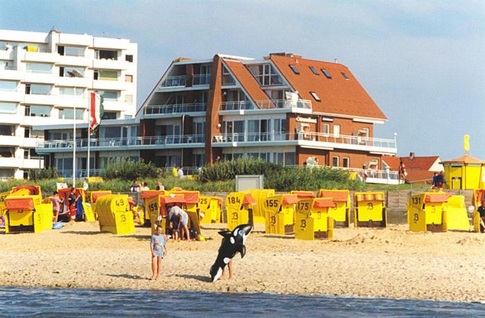 库克斯港Strandhaus Christiansen的海滩上的儿童和狗,有一座建筑