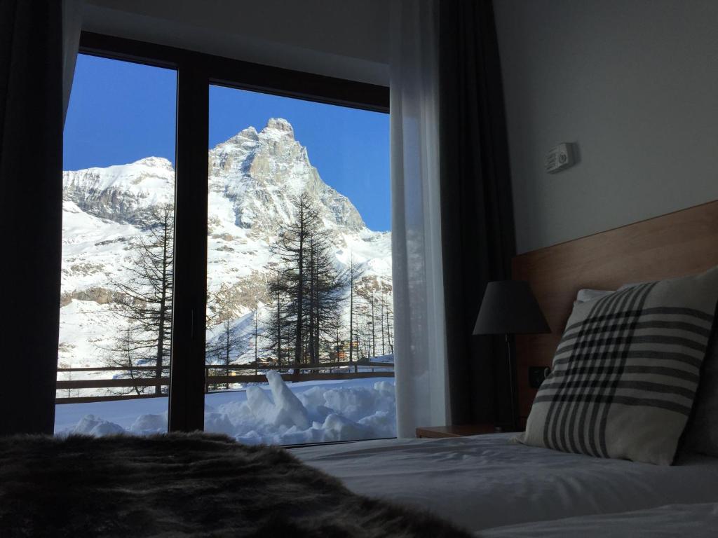 布勒伊-切尔维尼亚BASE CAMP alpine apartments的卧室享有雪覆盖的山脉美景