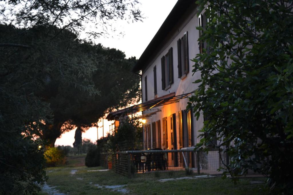 里奥托尔托Podere S.Giulia - casale S.Giulia的白色的房子,阳光照耀着窗户