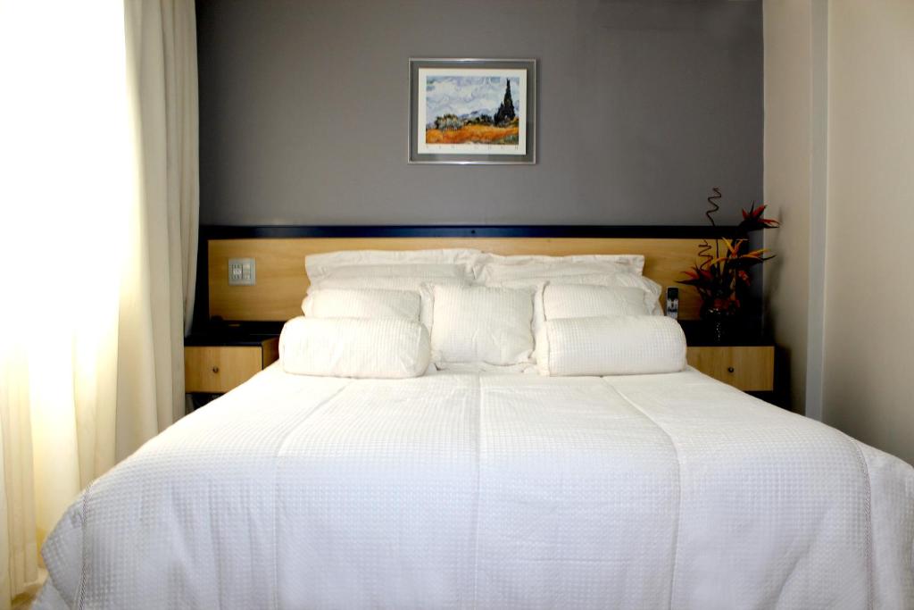 蒙蒂斯克拉鲁斯La Défense Apart Hotel的卧室配有白色的床和木制床头板