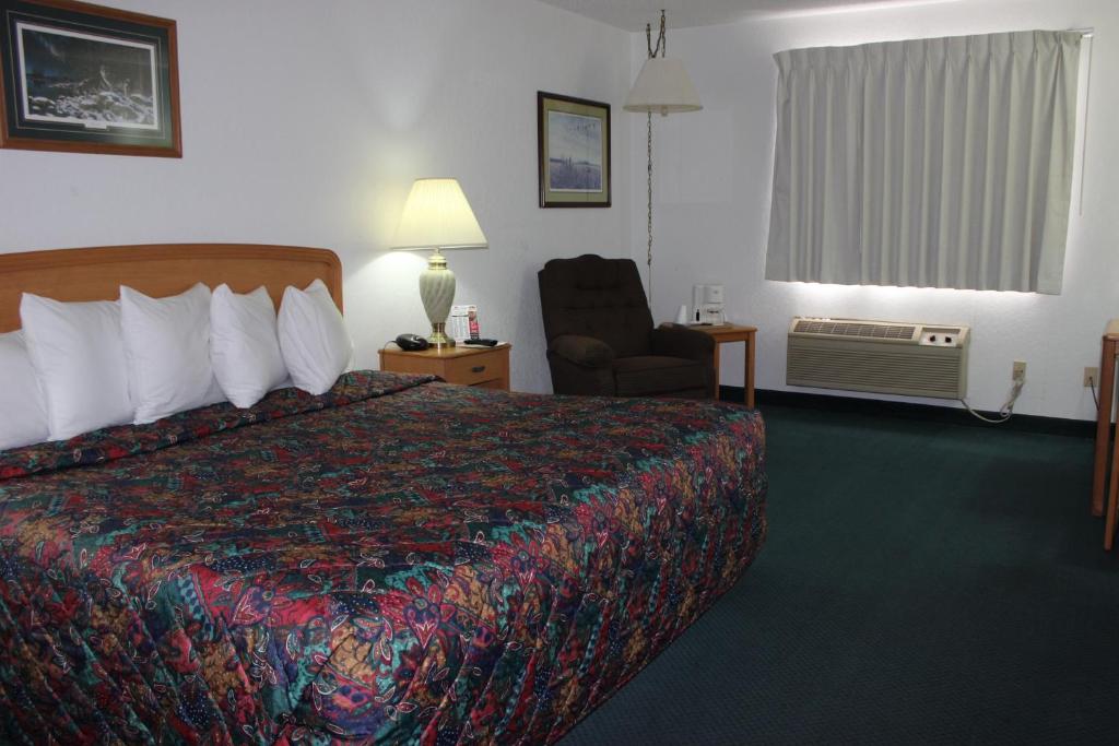 格兰福克格兰福克美国最佳价值旅馆的配有一张床和一把椅子的酒店客房