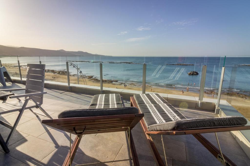大加那利岛拉斯帕尔马斯Living Las Canteras Homes - BEACHFRONT ROOFTOP的阳台配有两把椅子,享有海滩美景