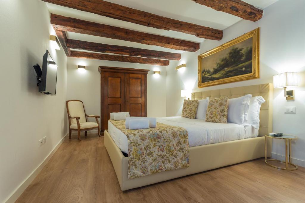 威尼斯Home Venice Apartments-Rialto 1 - 2 - 3的卧室配有白色的床和椅子