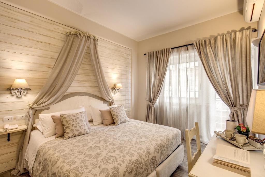罗马Casa Mia Vaticano Guest House的一间卧室配有一张床、一张书桌和一个窗户。