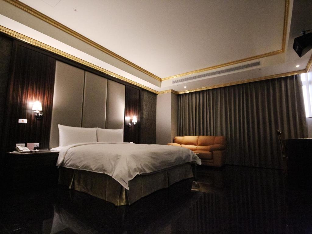 新竹金沙商务旅馆的配有一张床和一把椅子的酒店客房