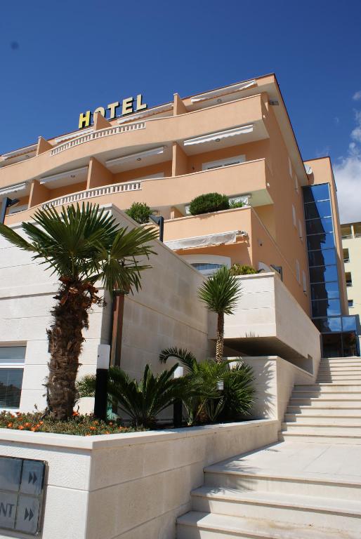 马卡尔斯卡罗西娜酒店的前面有楼梯和棕榈树的建筑