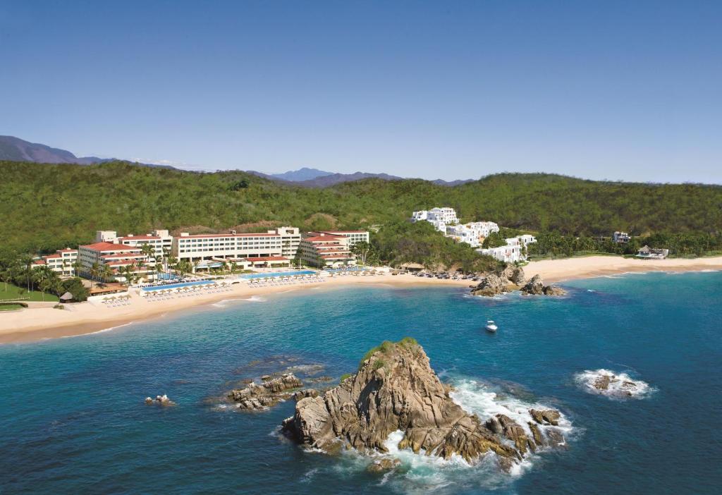 圣克鲁斯华特库瓦图尔科水疗梦幻度假酒店的享有海滩的空中景色,拥有建筑和山脉