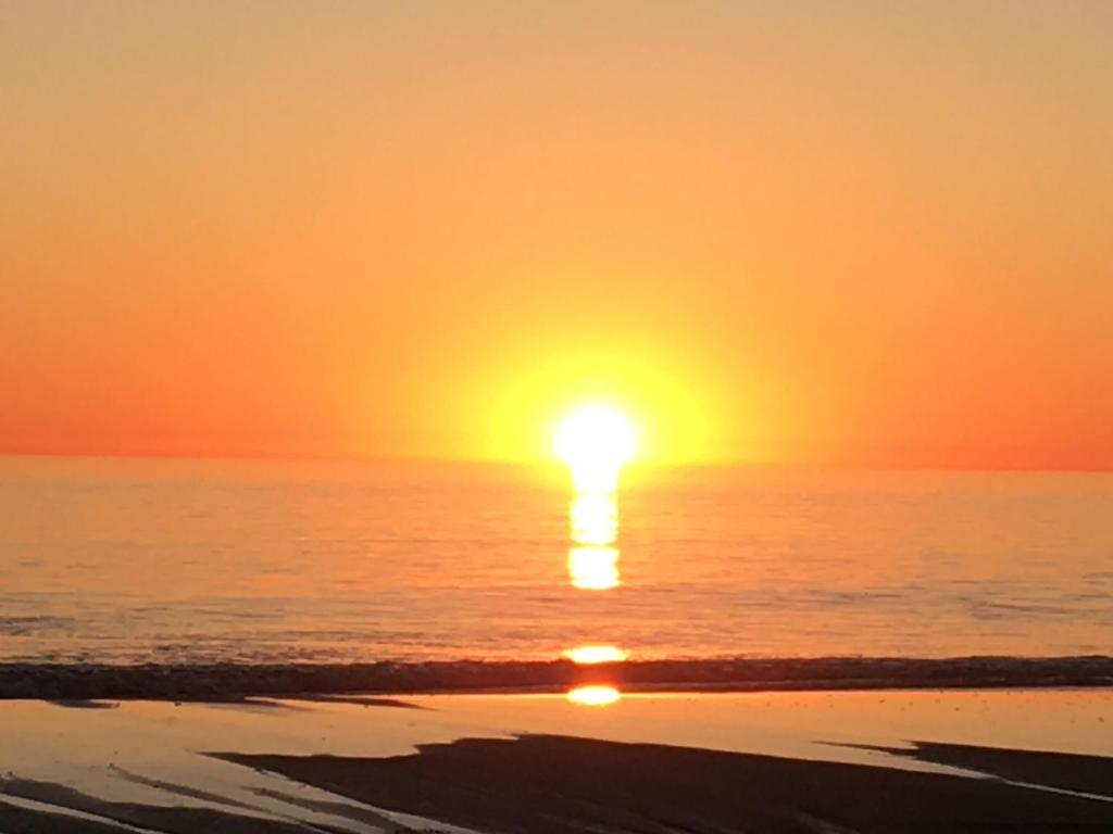 阿德莱德阿德莱德 - 信号海滨公寓的海滩上的日落,阳光在海洋上