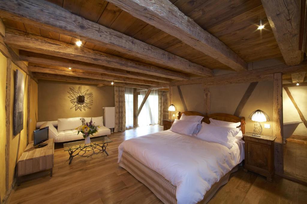 Zimmersheim麦森阿特格尔酒店的卧室配有一张白色的大床和一张沙发。
