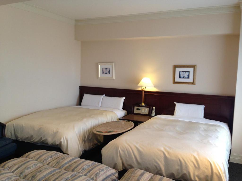 磐城克莱斯顿酒店的酒店客房设有两张床和一张桌子。