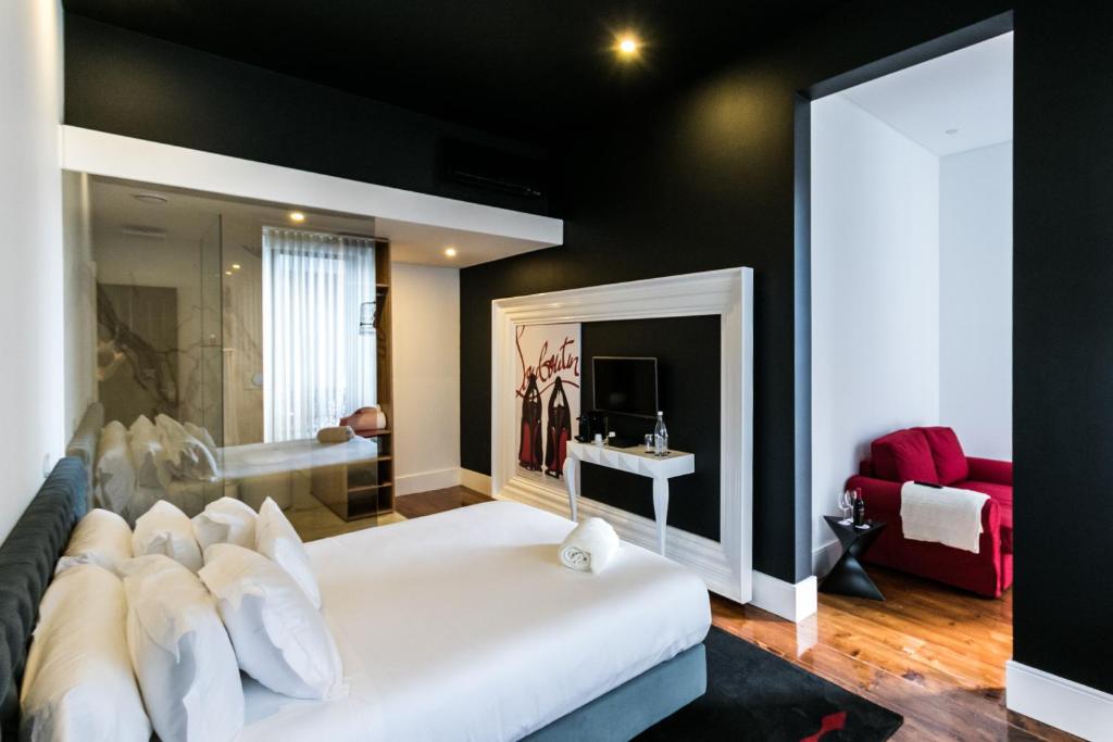 塞图巴尔RM The Experience - Small Portuguese Hotels的卧室配有白色的床和红色沙发