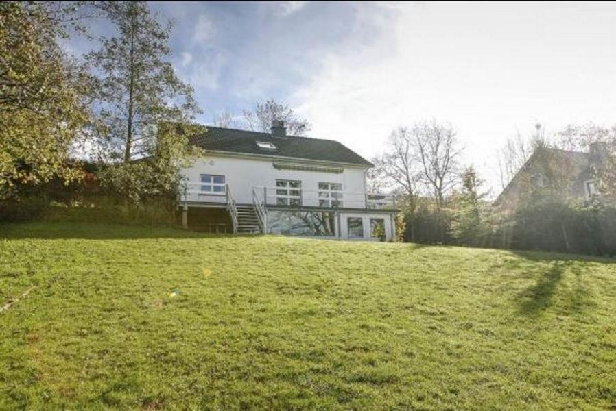 斯塔沃洛Val du Roannay的坐落在郁郁葱葱的绿色田野顶部的白色房子