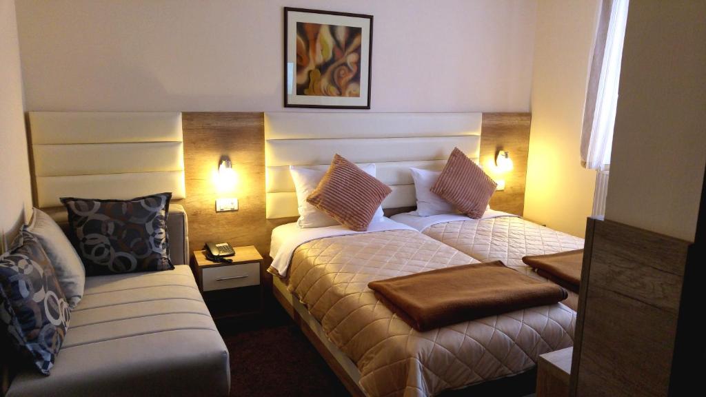科拉欣茨勒酒店的酒店客房,设有两张床和一张沙发