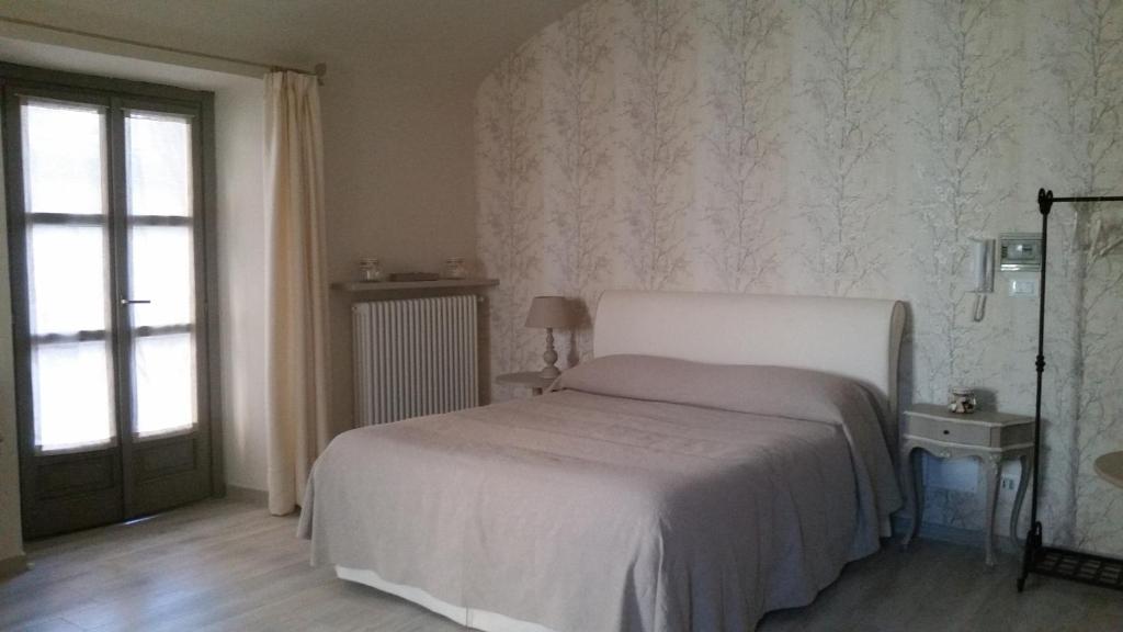 阿维利亚纳Novecento Charming Room的卧室配有白色的床和窗户。