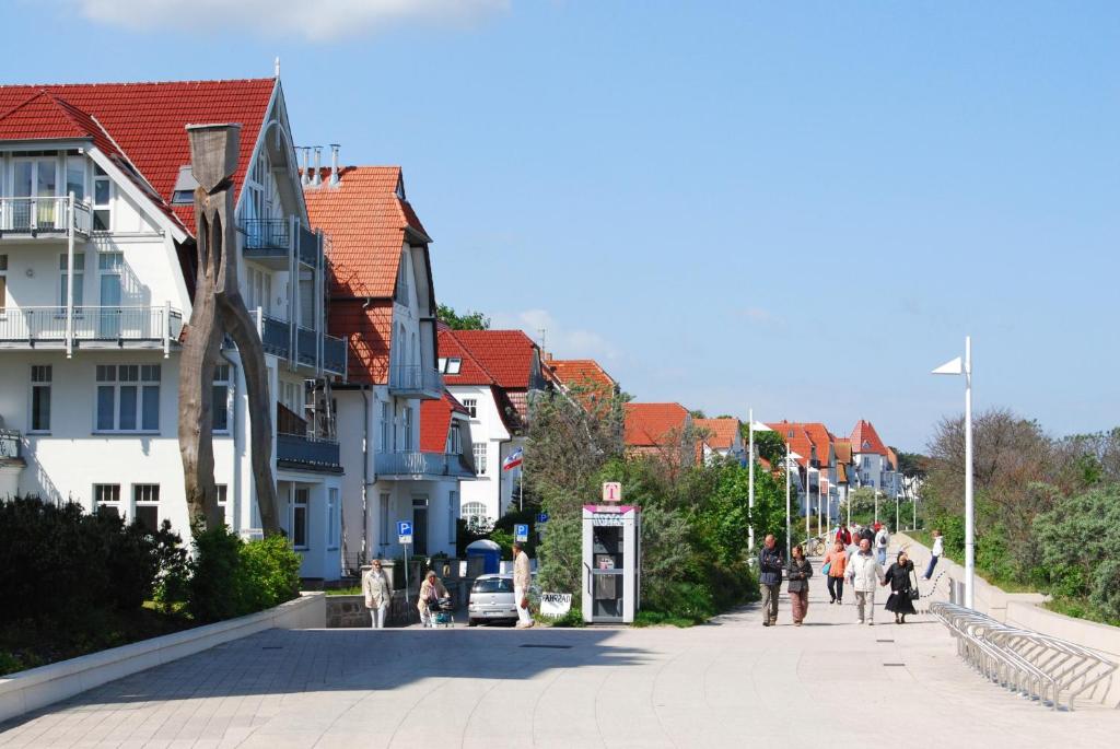 瓦尔内明德Ferienwohnung Warnemünde L (S)的一群人沿着街道走着,街道上有许多建筑