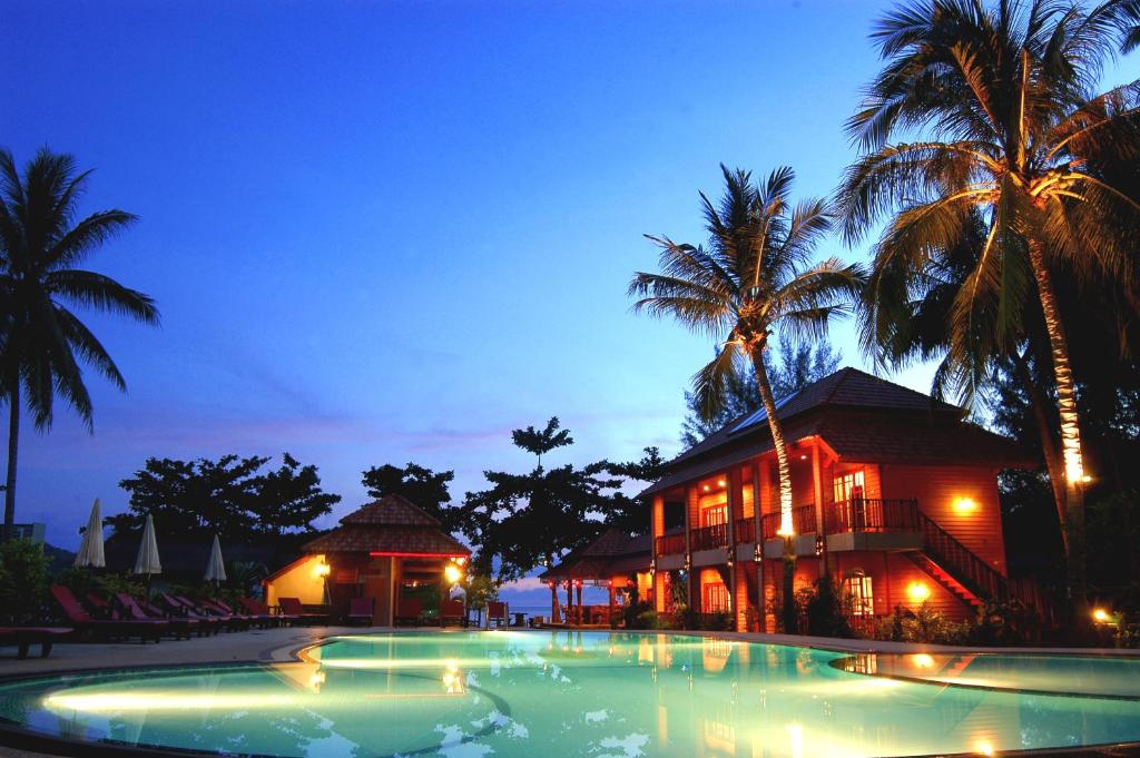 通奈潘海滩帕岸岛哈瓦那海滩度假酒店的棕榈树建筑前的游泳池