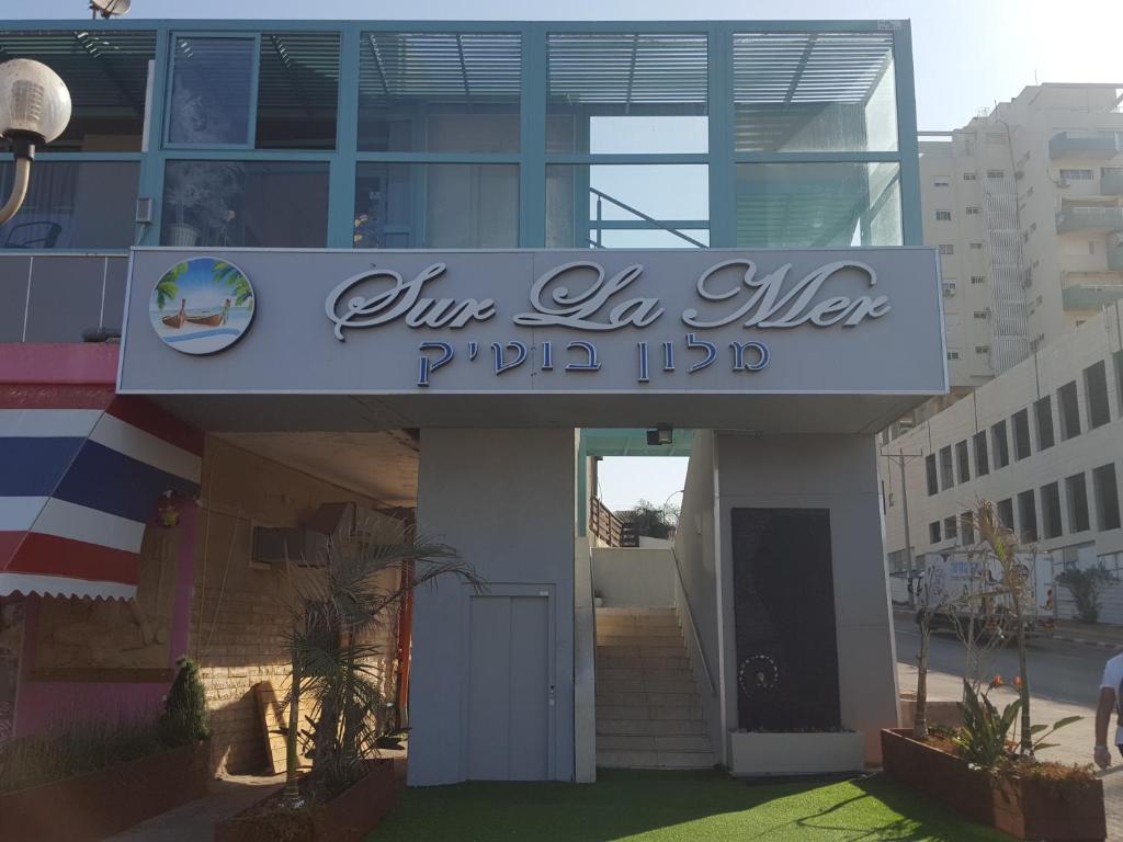 阿什杜德Sur La Mer Hotel Ashdod的带有读取Ja la alhamptapta iidb的标志的建筑