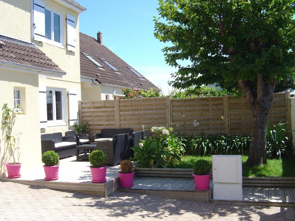 Bernières-sur-MerGîte de Eric et Rose的围栏前种有盆栽植物的花园