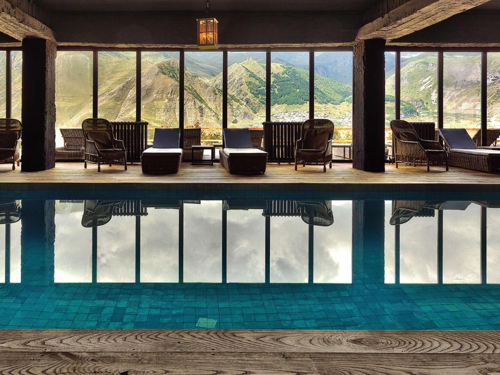 卡兹贝吉卡兹别吉客房酒店的一个带椅子的游泳池,享有山景